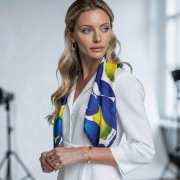 Kobieta w białej marynarce z apaszką Lemons zarzuconą na ramiona wokół szyi More Amore