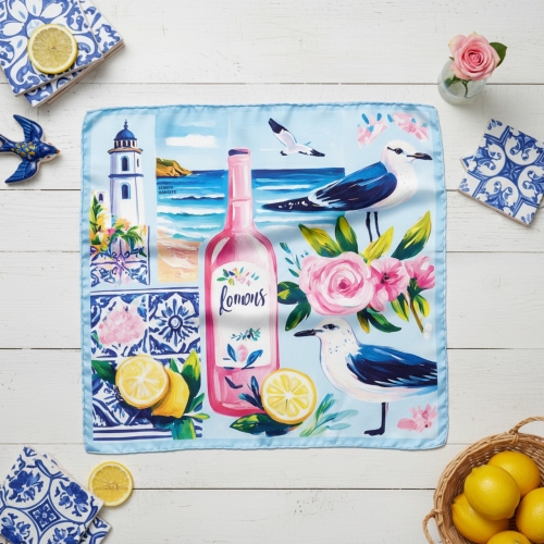 Rozłożona apaszka jedwabna Postcard 67 × 67 cm na jasnym drewnianym stole More Amore