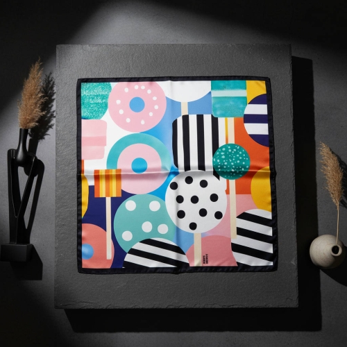 Jedwabna apaszka Sweet &amp; Spicy 67 × 67 cm ułożona na ciemno szarym tle More Amore
