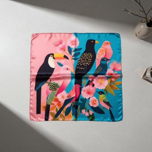 Apaszka jedwabna Bird 53 x 53 cm ułożona na jasnym stole More Amore